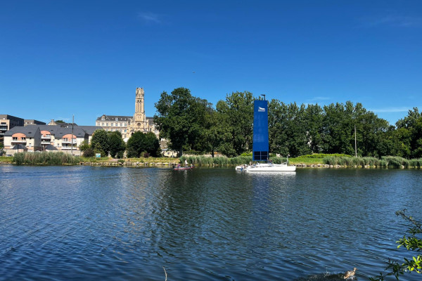 Vue du canal avec un voilier devant le Petit Lourdes à Hérouville-Saint-Clair, photo jointe au brief, crédit Léa Génard.